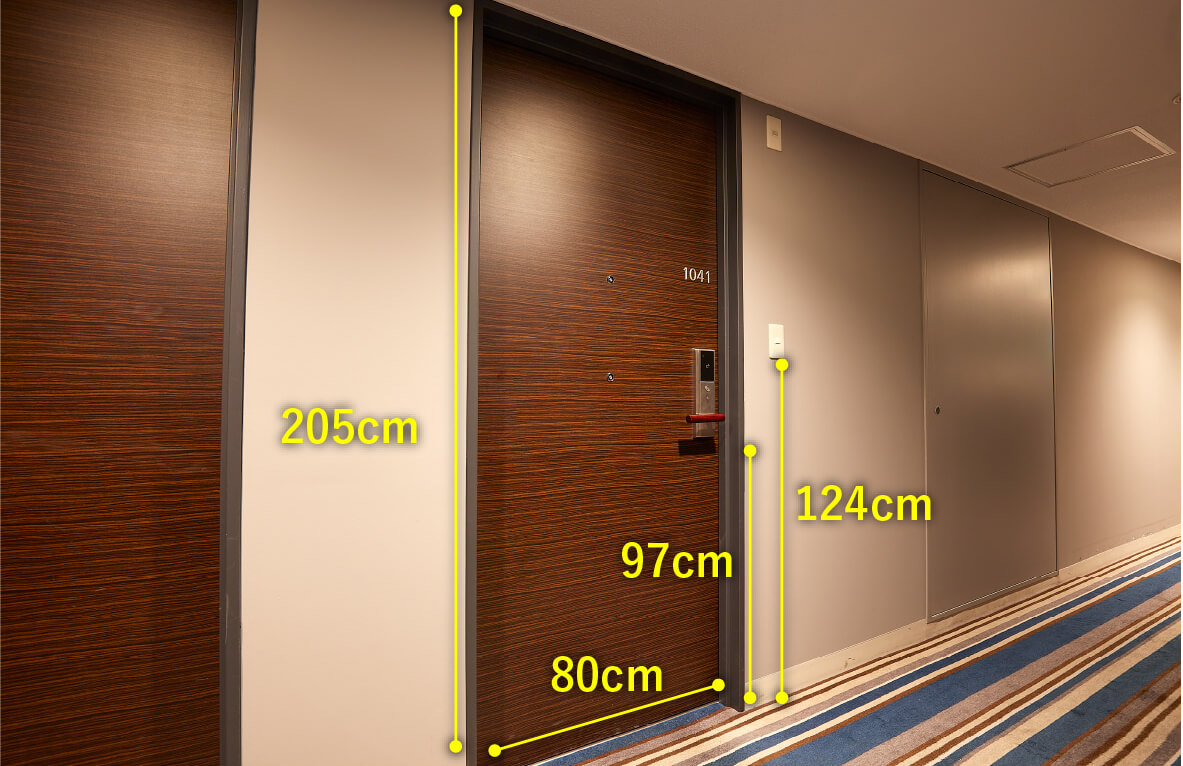 ユニバーサルルームのドア廊下側サイズ　横幅80センチメートル　高さ205センチメートル　取っ手までの高さ97センチメートル　呼び鈴までの高さ124センチメートル